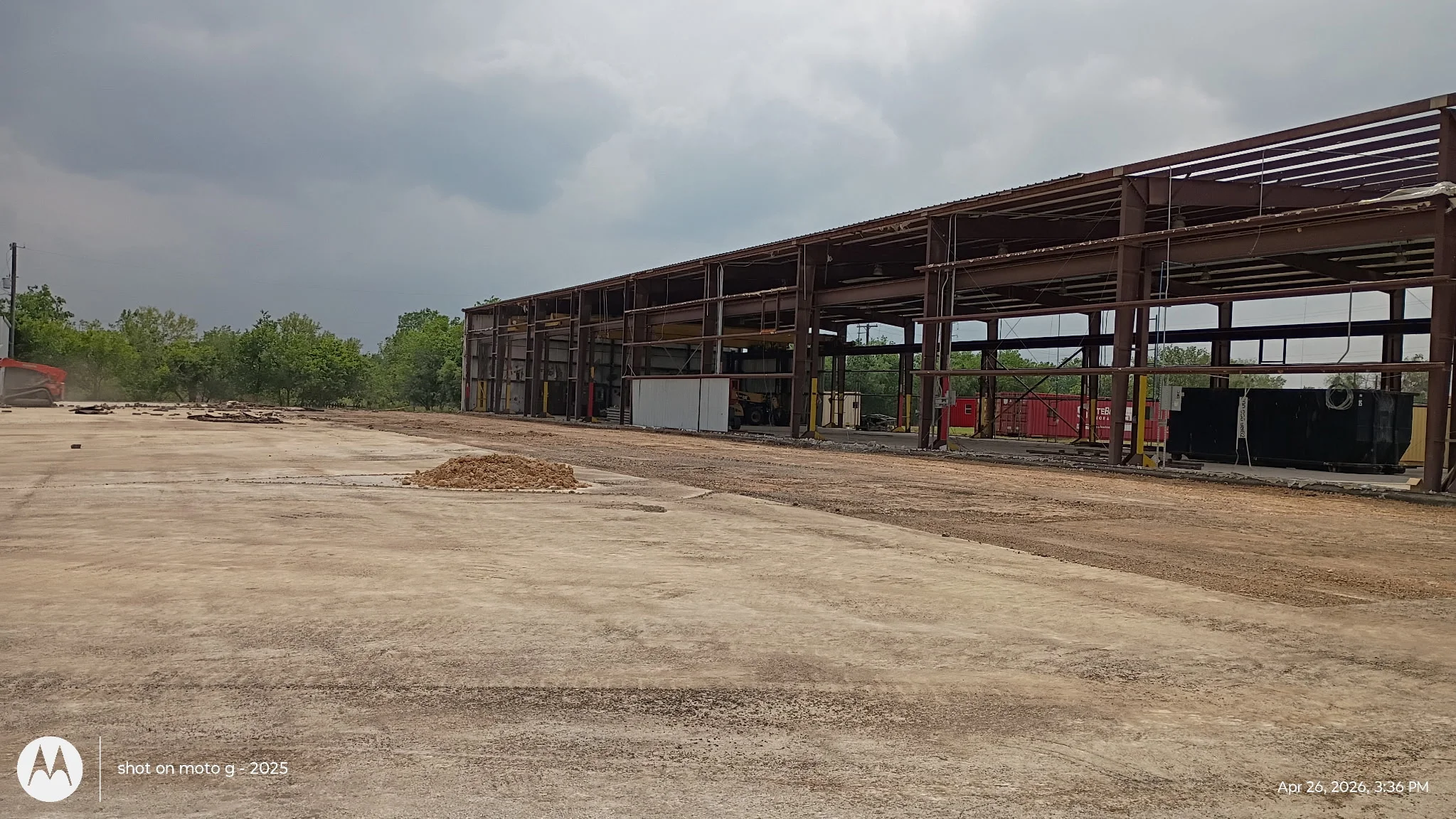 Cleared industrial demolition site with exposed concrete foundation and steel frame debris removal