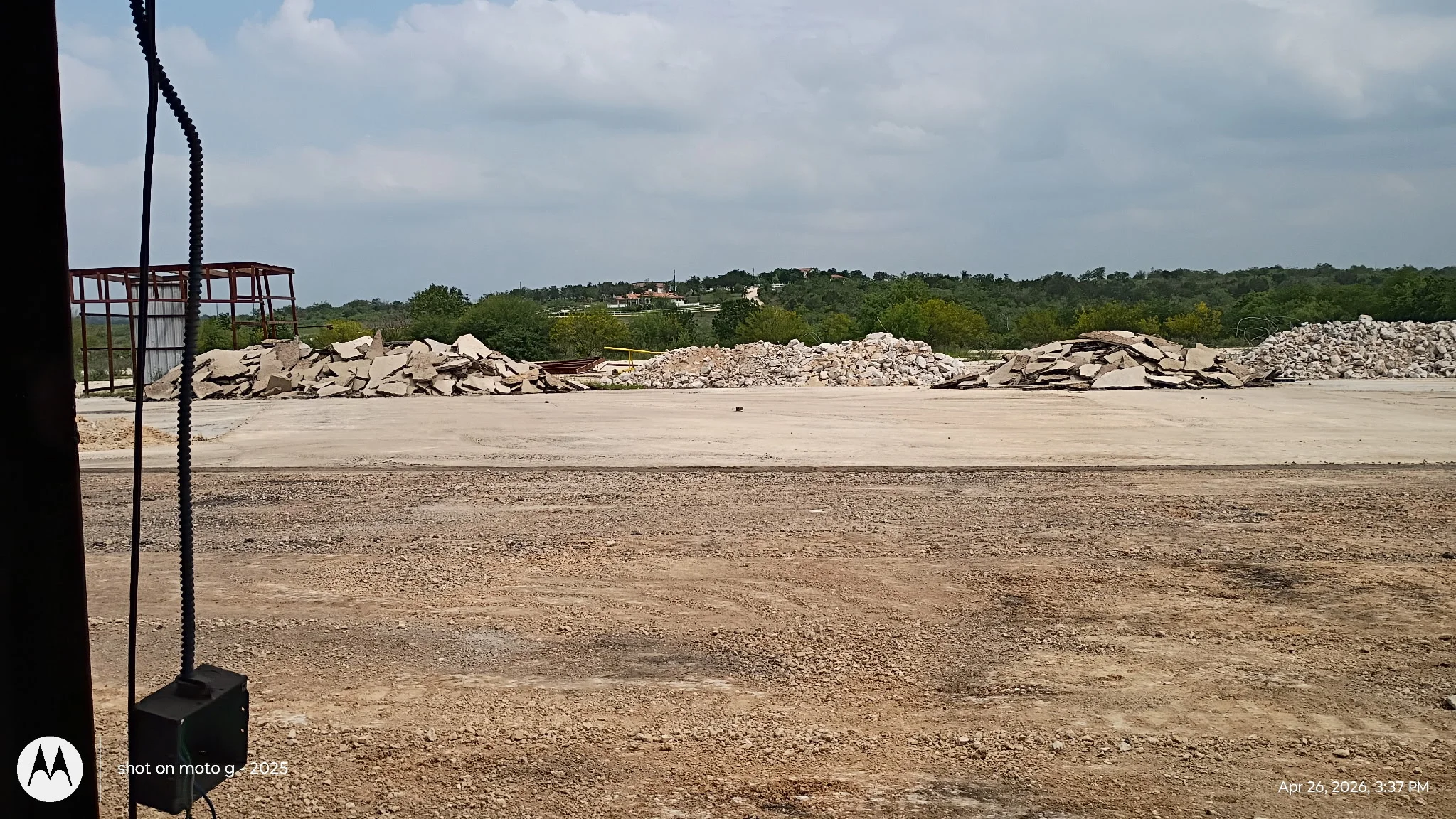 Demolition debris piles including concrete, masonry, and mixed materials staged on cleared lot